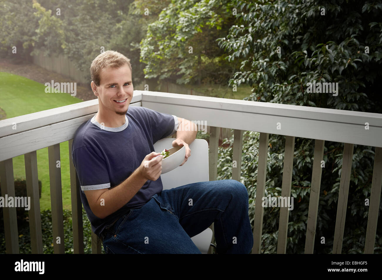 Jeune homme ayant balcon sur salade Banque D'Images