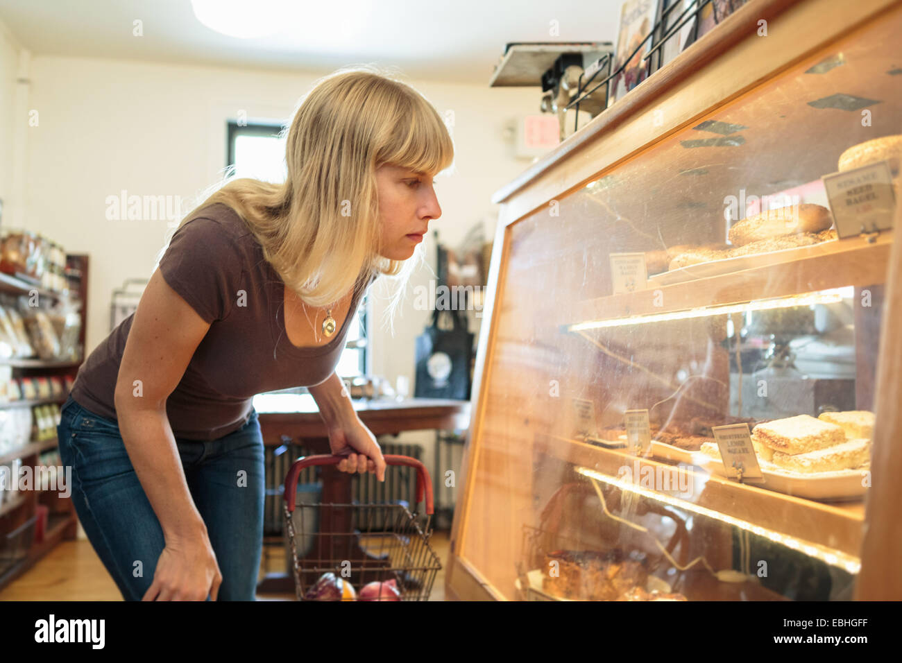 Female customer looking at display cabinet in country store Banque D'Images
