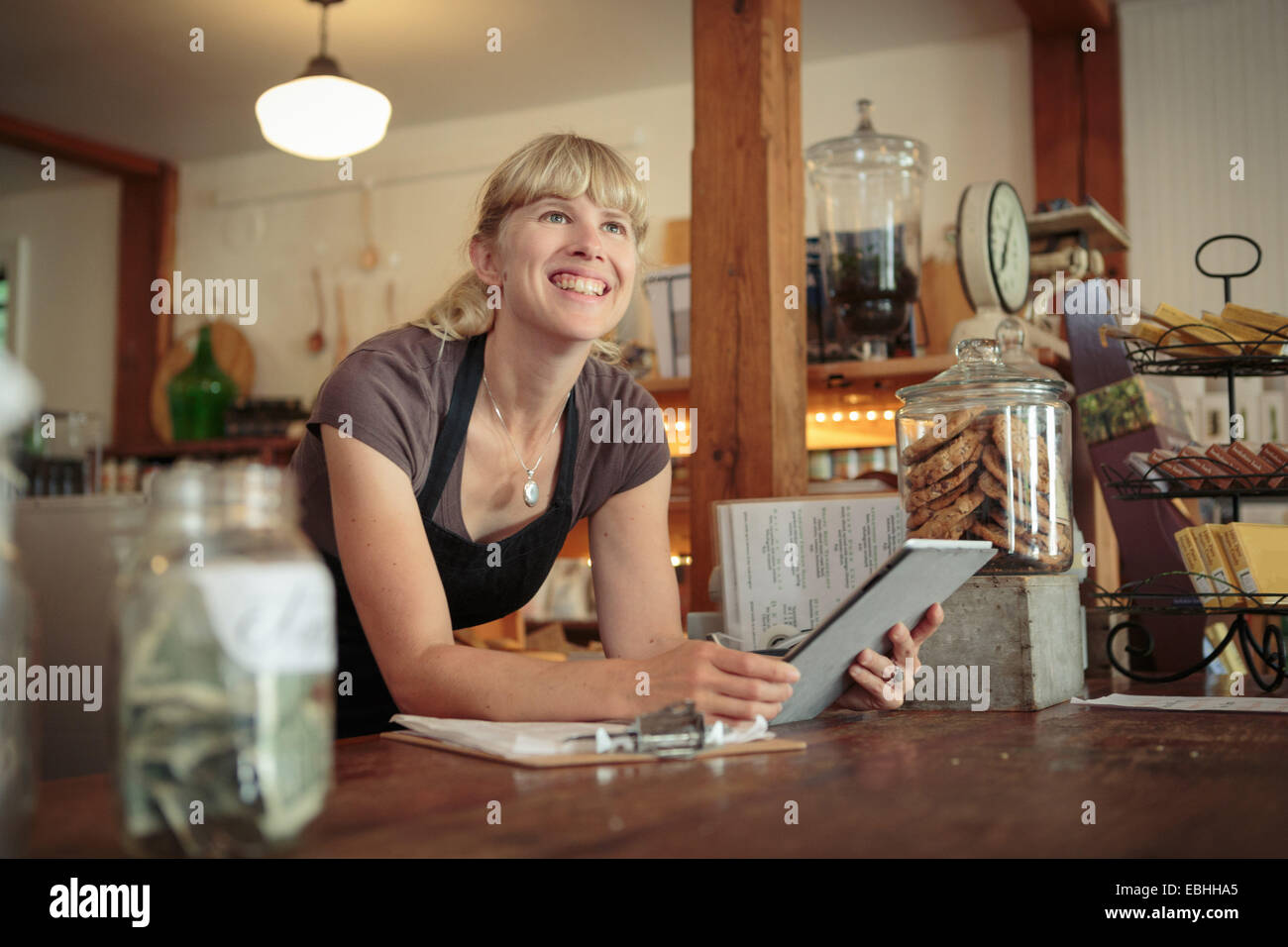 Femme shop assistant with digital tablet in country store Banque D'Images