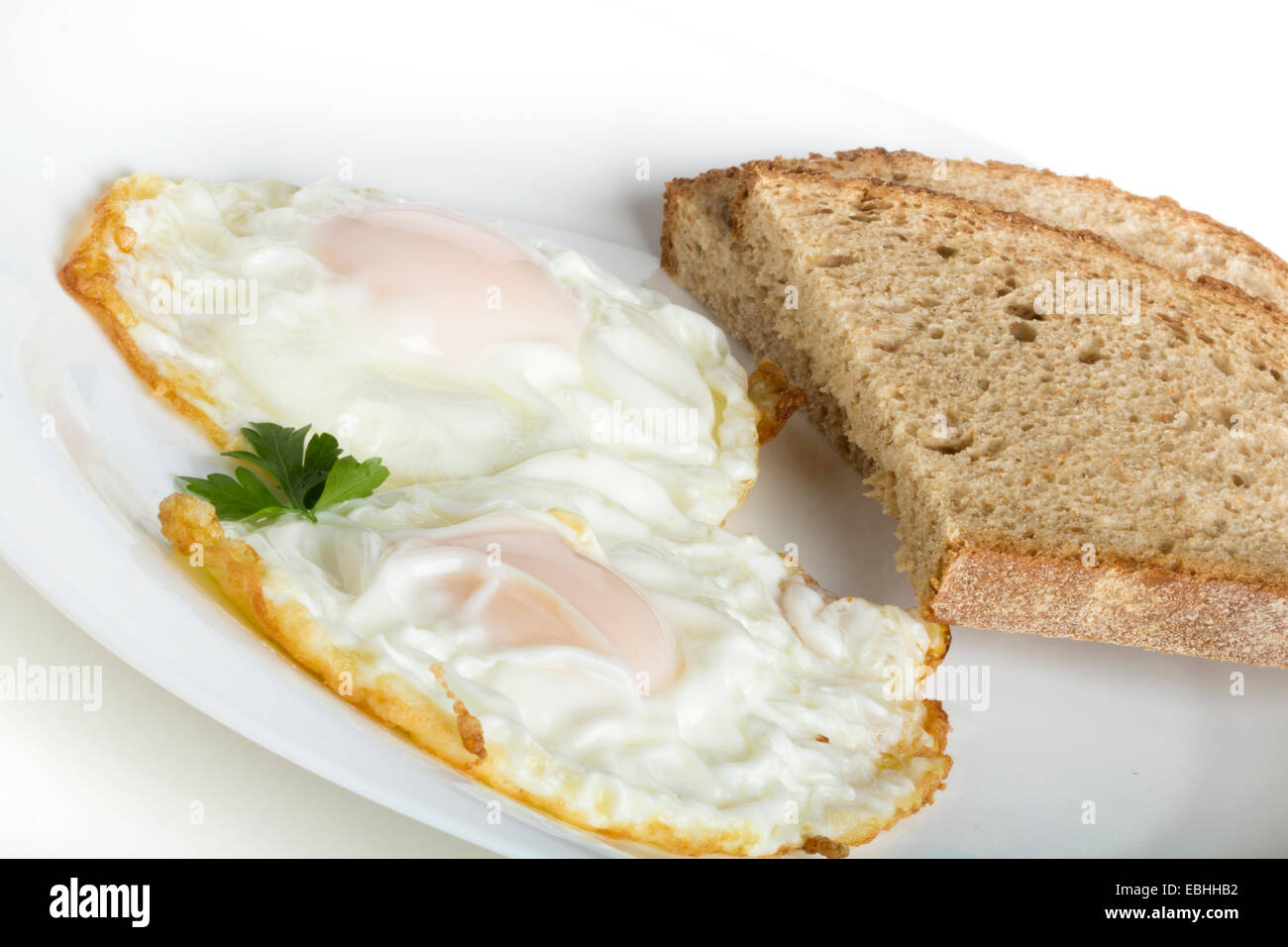 Deux œufs et du pain isolé sur fond blanc Banque D'Images
