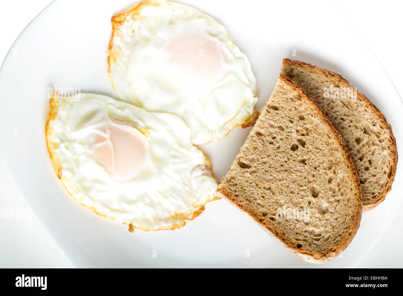 Deux œufs au salami et de pain sur une plaque blanche Banque D'Images