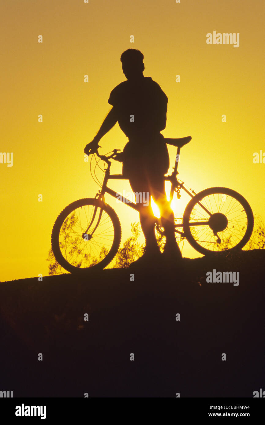 Silhouette d'homme Biker au coucher du soleil Banque D'Images