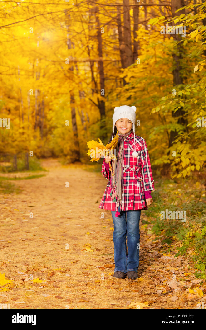 Cute Asian girl avec des tas de feuilles jaunes seul Banque D'Images
