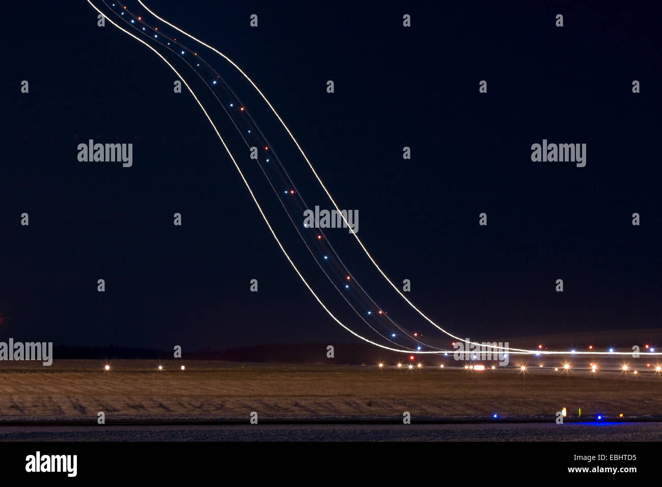 Des sentiers de lumière un avion décolle dans la nuit de l'aéroport de Skavsta, Suède. Banque D'Images