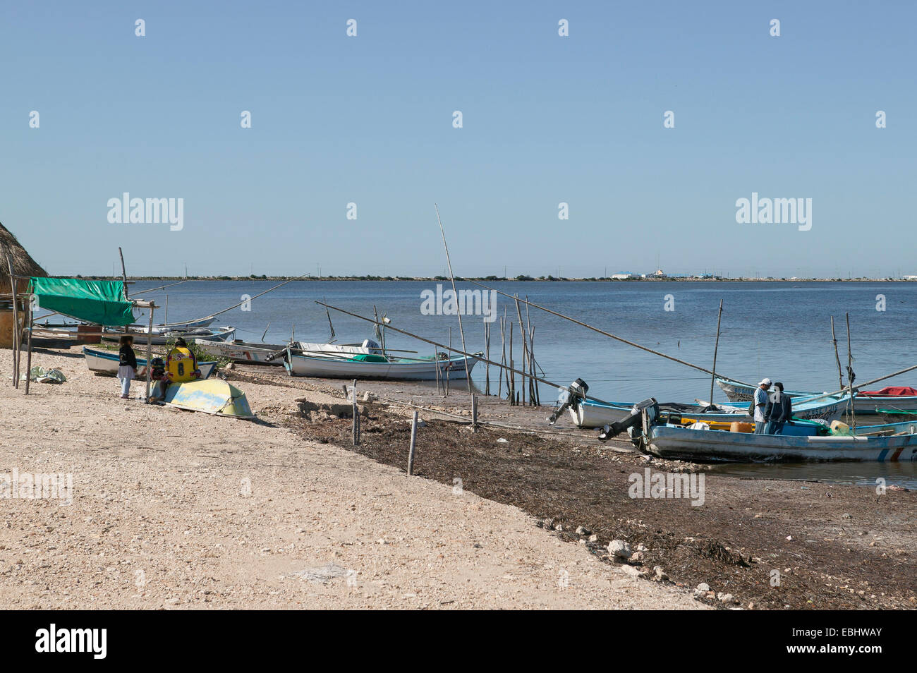Deux pêcheurs debout dans l'un des nombreux bateaux échoués sur la panga avec de longues cannes à pêche en bambou le long de la côte du Mexique Guf à Campeche, Mexique. Banque D'Images