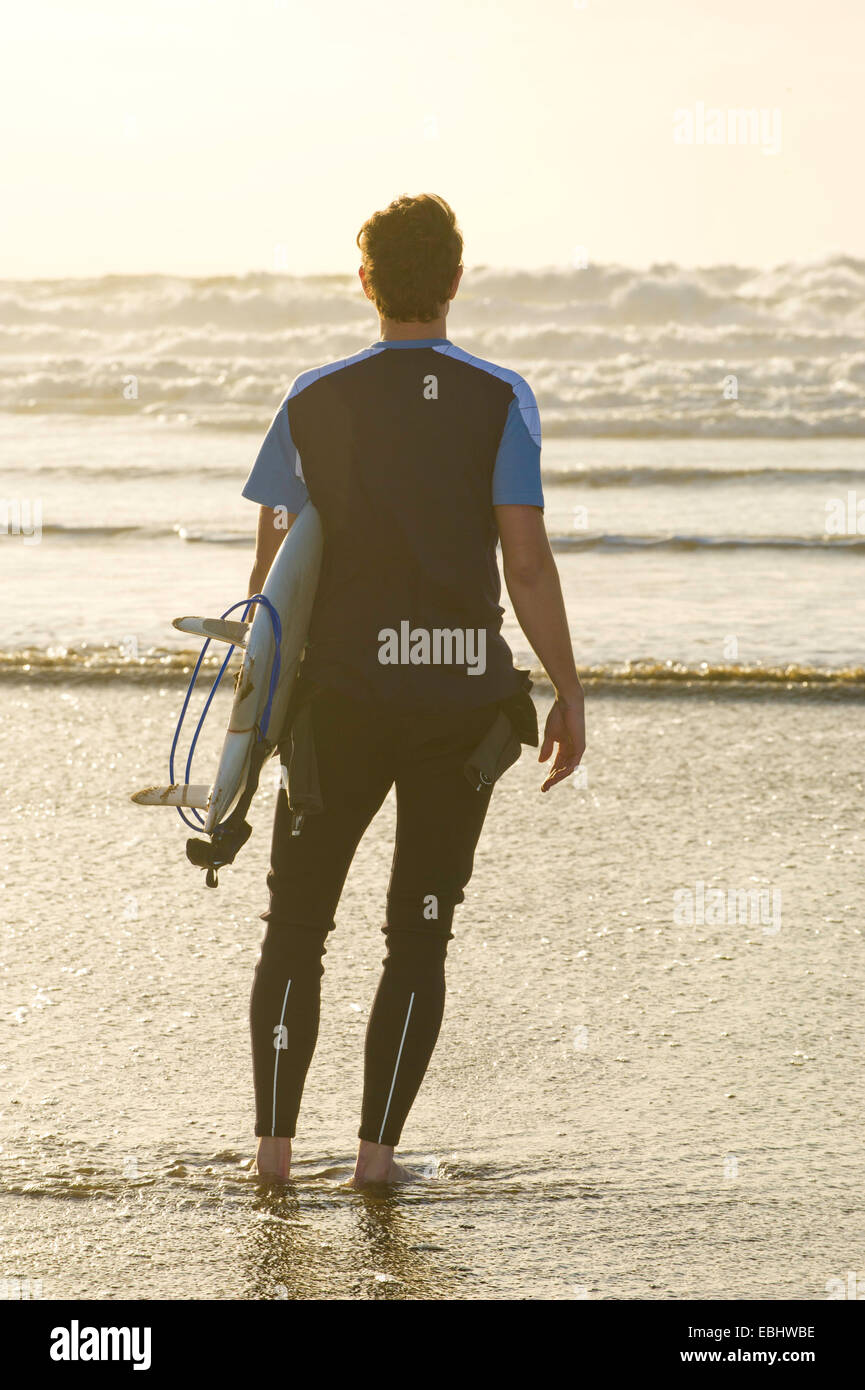 Regardant la mer Surfer holding surfboard Banque D'Images