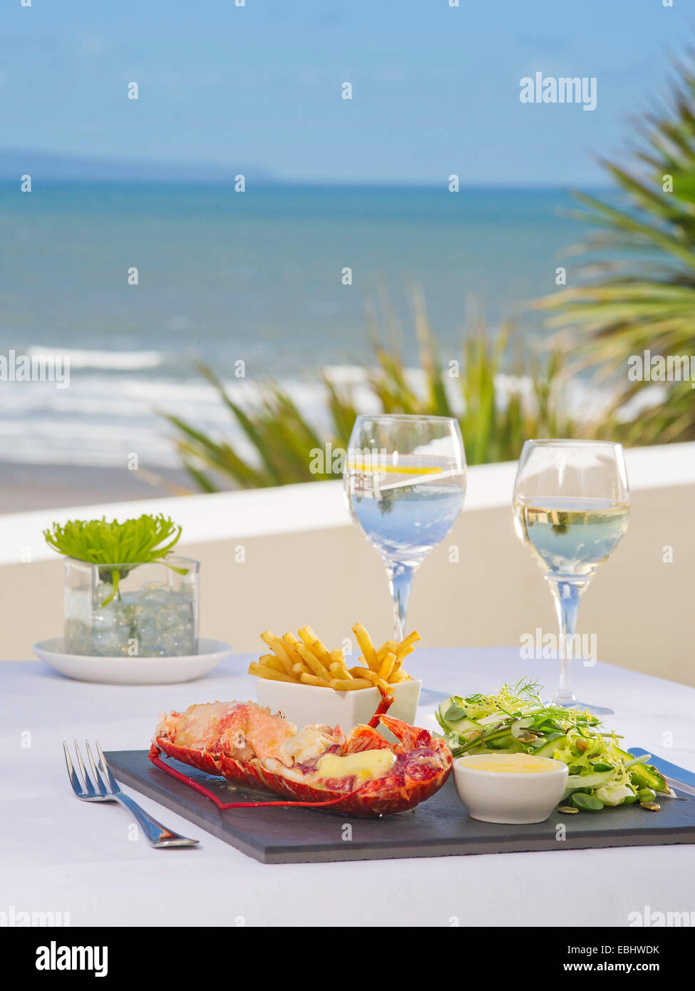 Le homard avec les frites sur une plaque avec la mer en arrière-plan. Banque D'Images