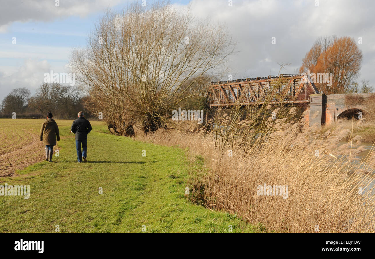 Promenade masculine et féminine sur un chemin près De La rivière Avon avec un pont ferroviaire de chemin de fer en métal disiosed près de Stratford upon Avon, Warwickshire, Angleterre, Royaume-Uni Banque D'Images