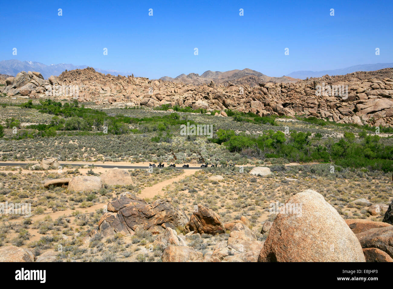 Vue panoramique sur les plaines et boulder-comme rocheux des Alabama Hills avec certains bikers se reposant au bord d'une route de campagne, États-Unis, Californie, Lone Pine Sanctuary Banque D'Images