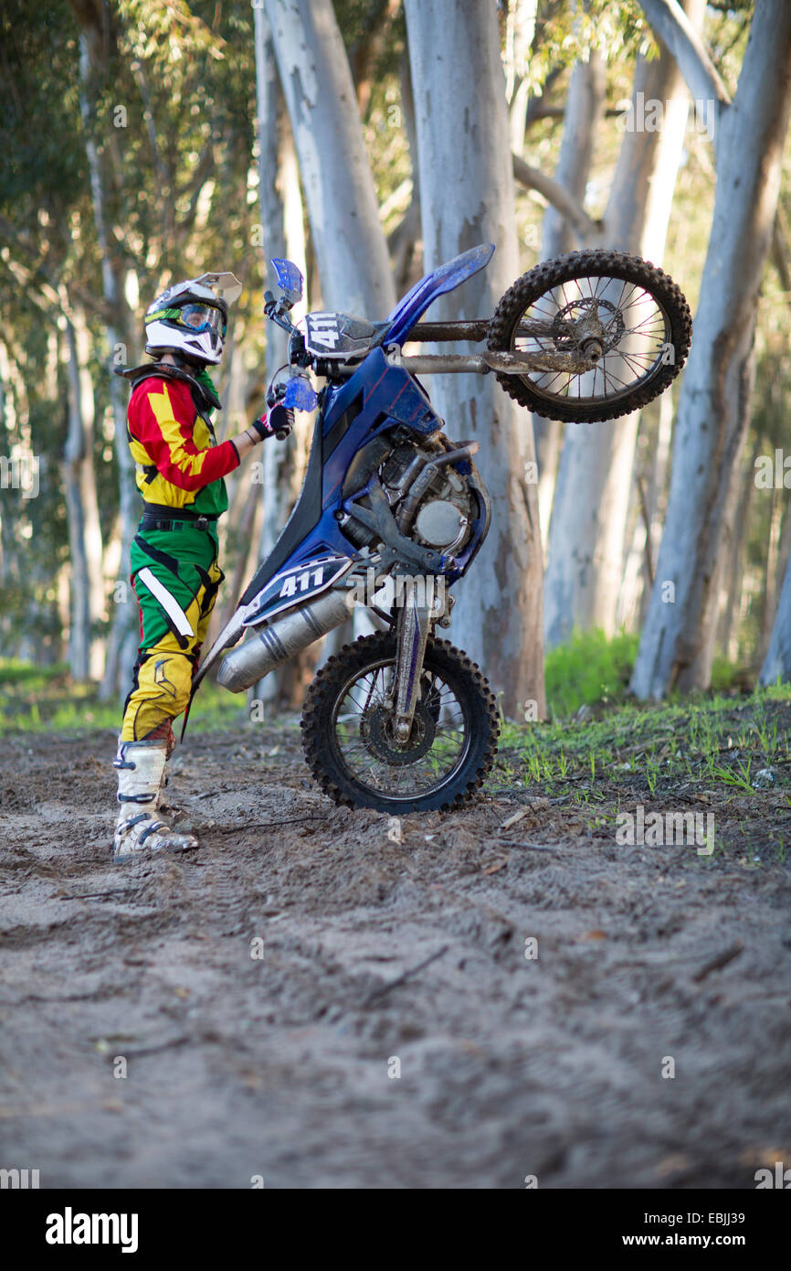 Jeune homme racer motocross moto avec commandes sur piste en forêt Photo  Stock - Alamy