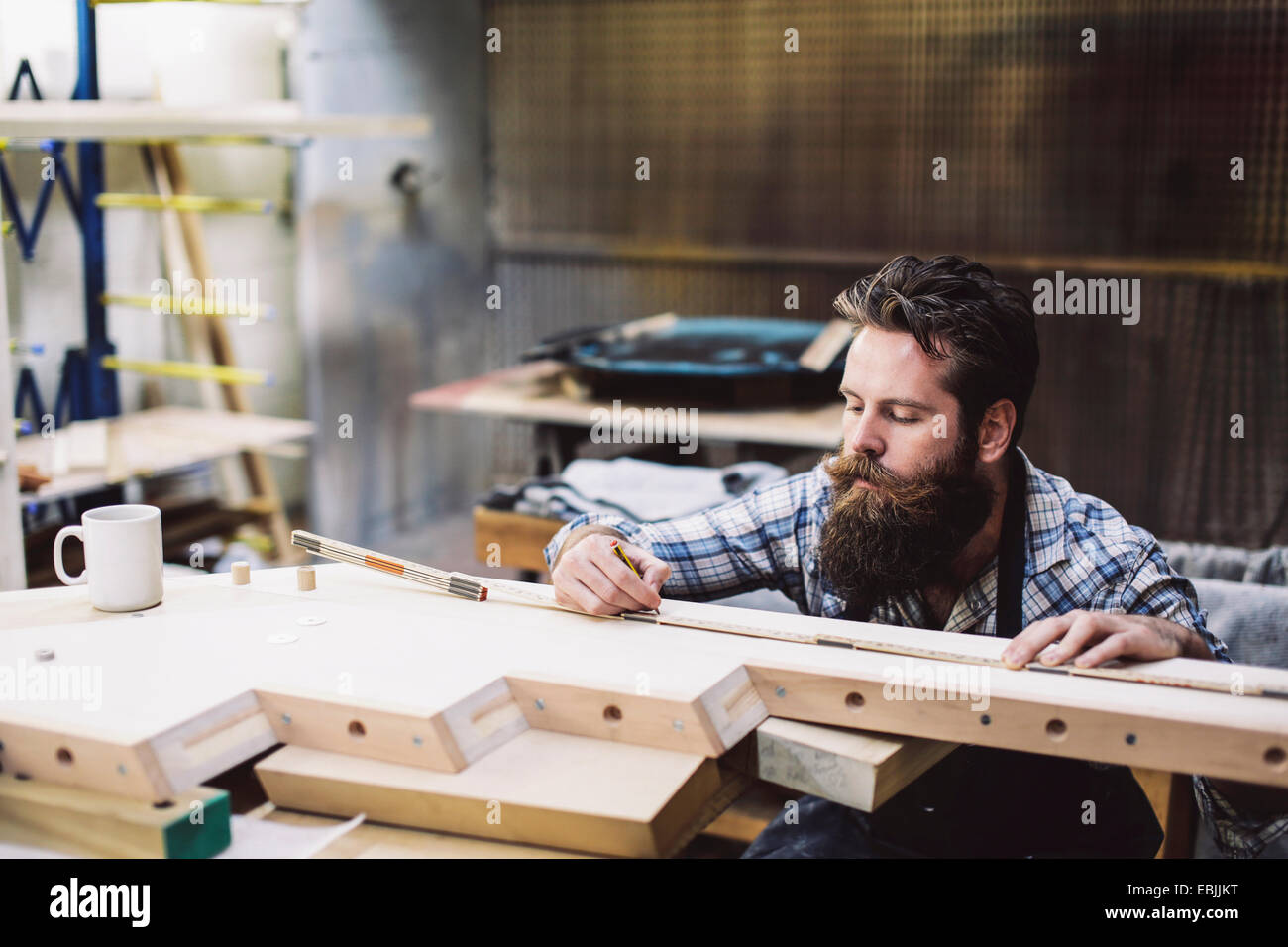 Cropped shot of mid adult artisan bois de mesure en atelier d'éléments Banque D'Images