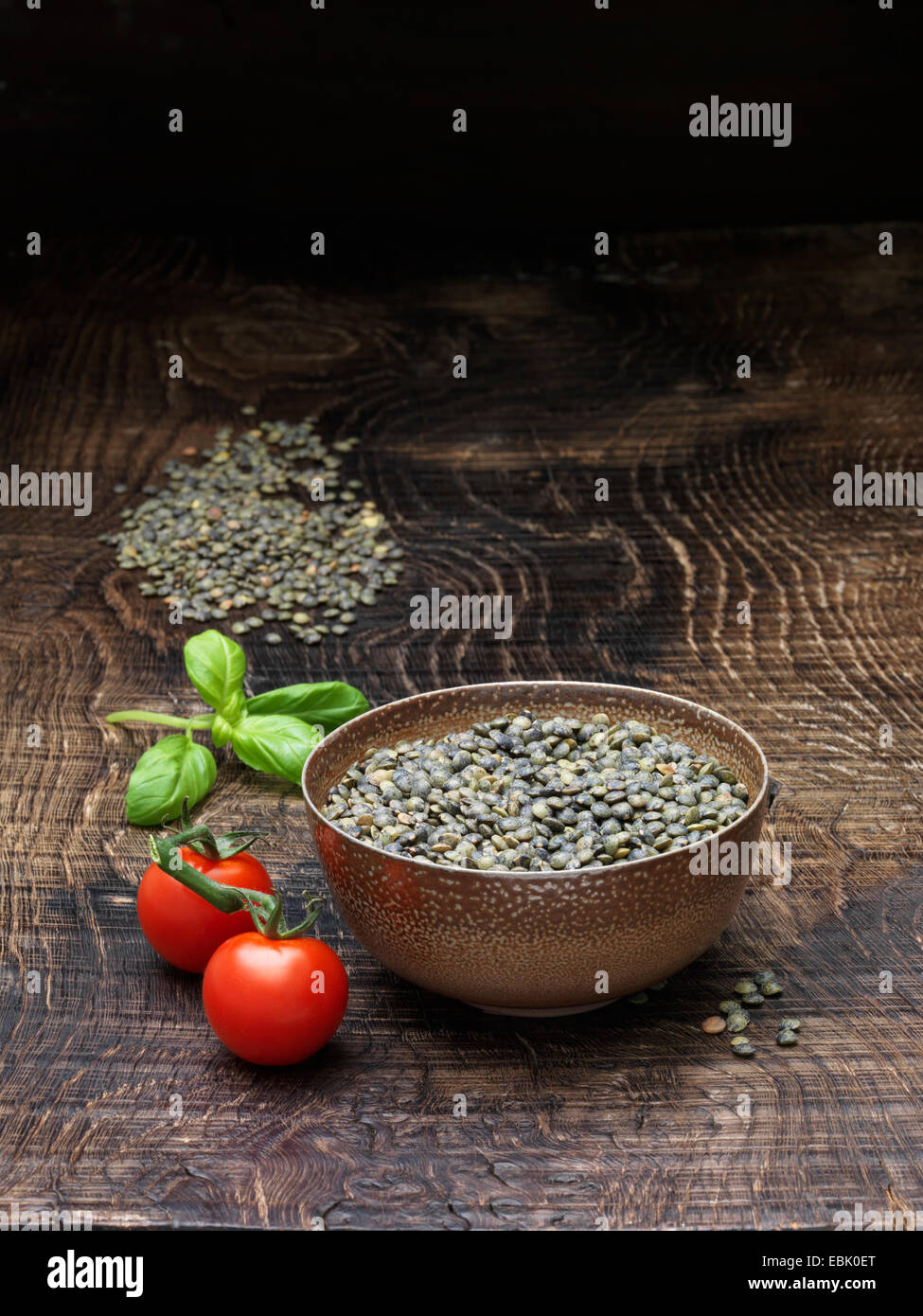 Nature morte avec tomates, basilic frais et bol de lentilles du Puy Banque D'Images