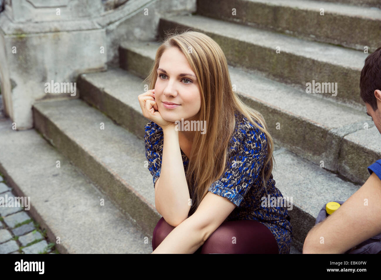 Jeune femme assise sur l'escalier de la vieille rue de la rêverie Banque D'Images