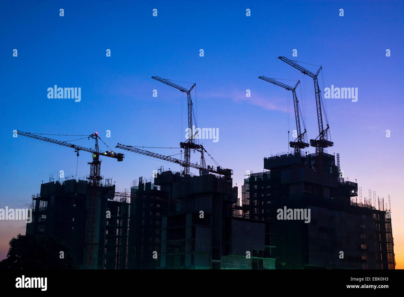 La construction d'immeubles dans la capitale, les grues de construction bâtiment et silhouettes avec Twilight Banque D'Images