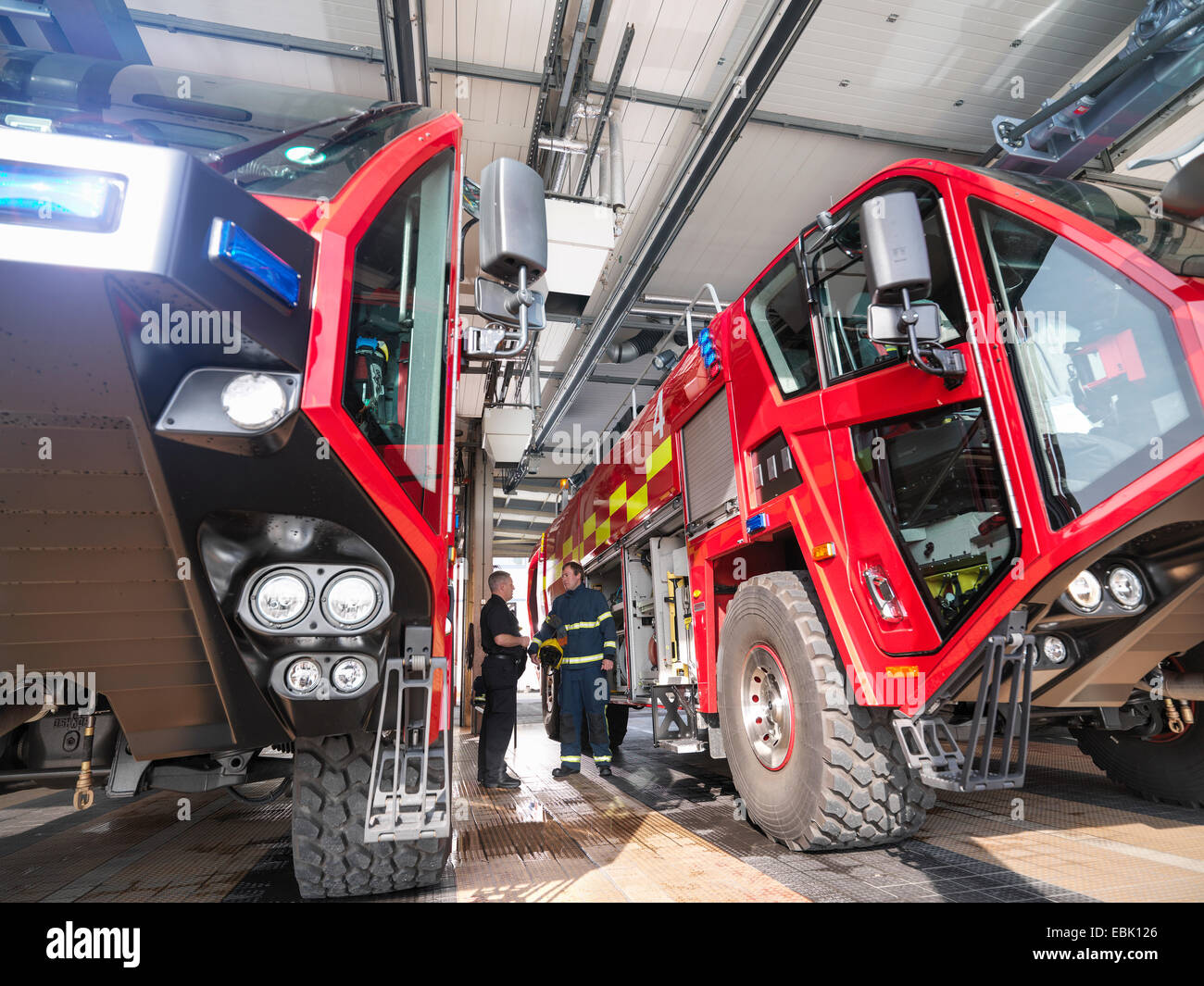 Pompiers en discussion entre les camions de pompiers ?� la caserne de pompiers de l'a?�roport 
