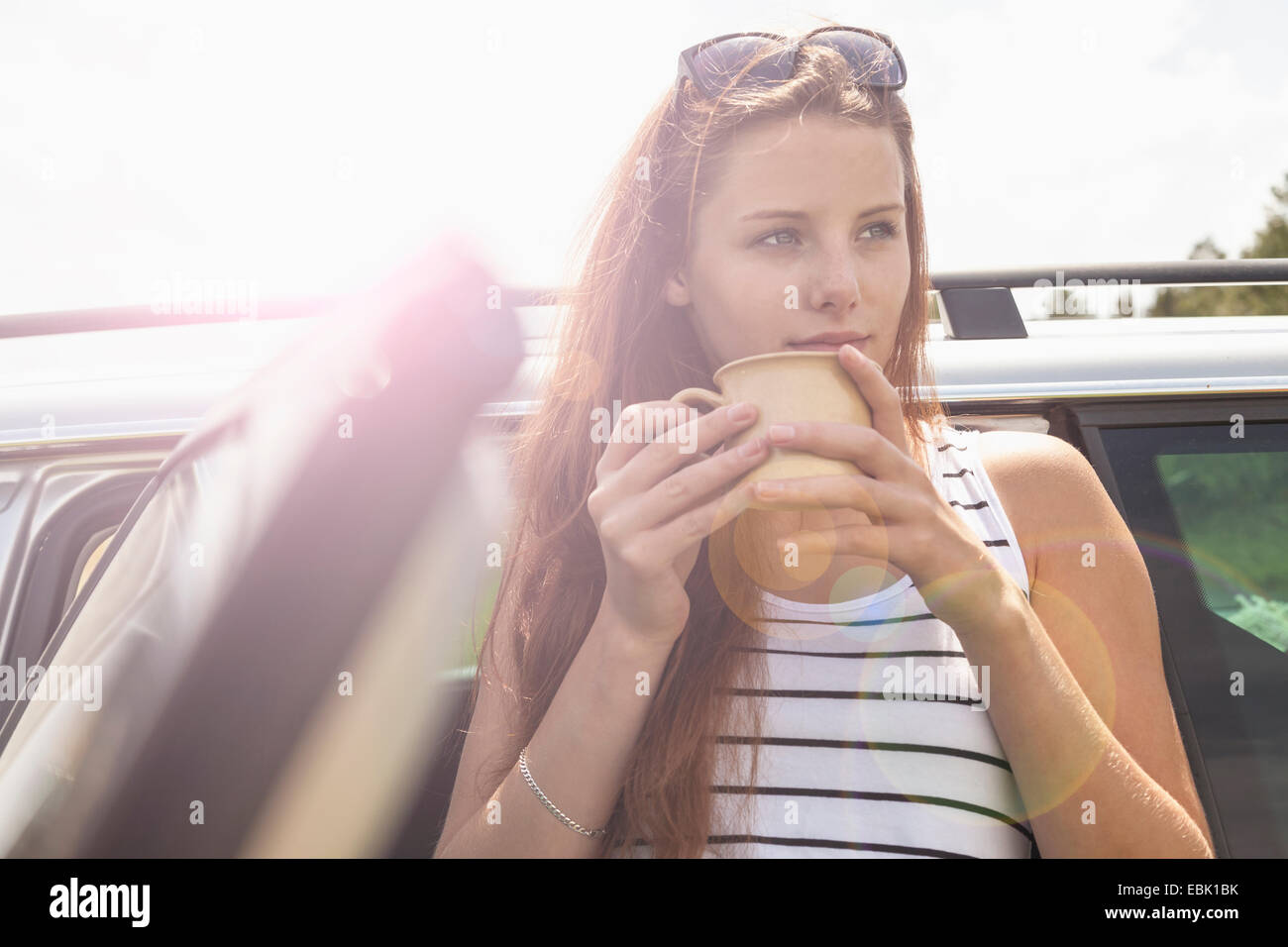 Young woman having coffee break on road trip Banque D'Images