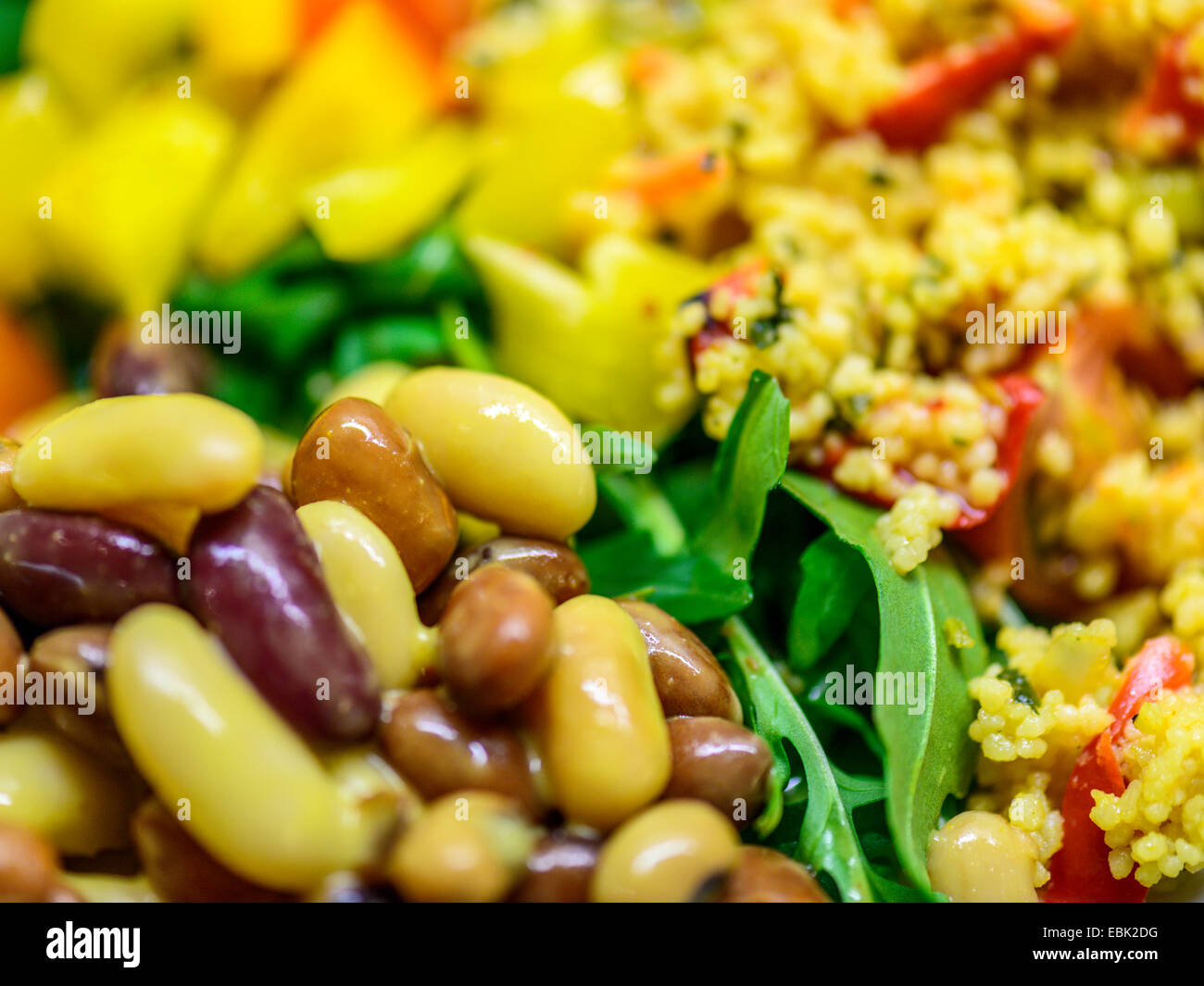 Salade Mixte dynamique saine de Brown et des haricots jaunes avec wild rocket, le poivron rouge et le couscous. Banque D'Images