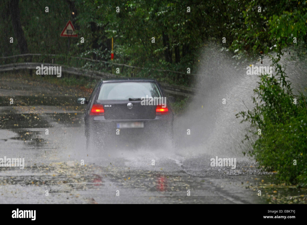 Une voiture passe à travers la route inondée, Allemagne Banque D'Images