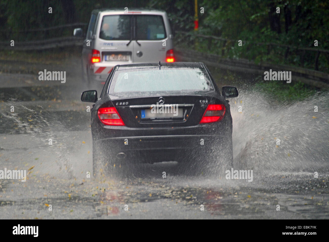 Une voiture passe à travers partiellement inondé road, Allemagne Banque D'Images