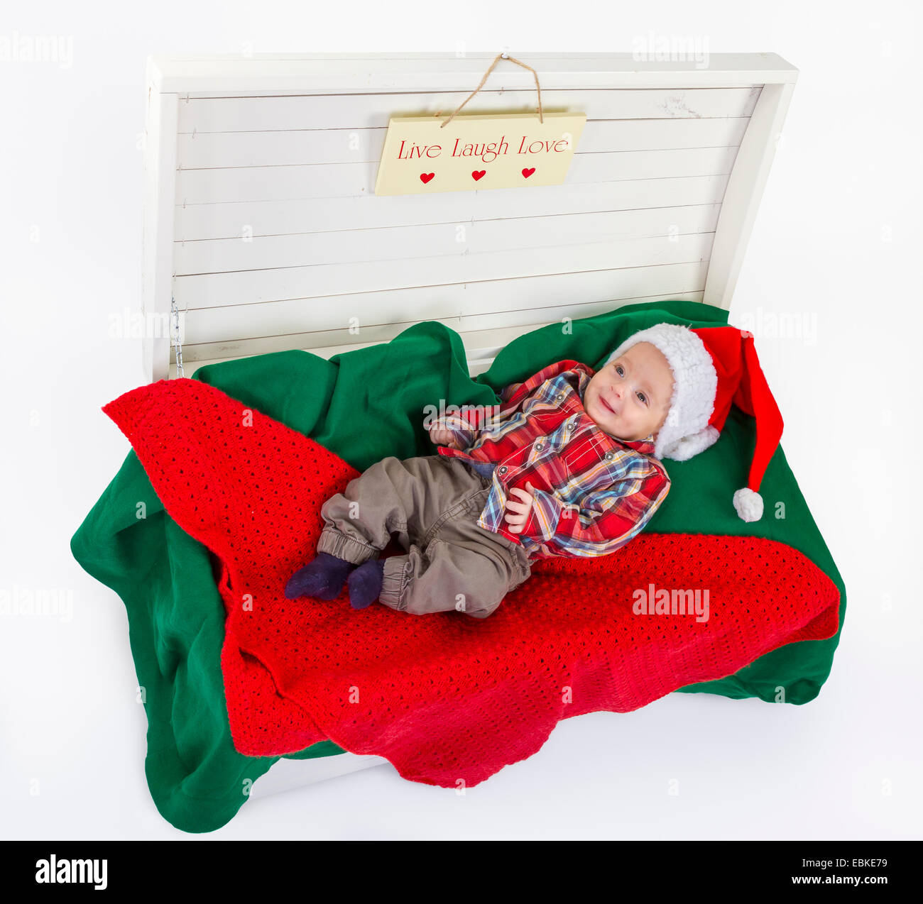 Mignon bébé garçon avec un chapeau de Père Noël dans un coffret en bois sur fond blanc Banque D'Images