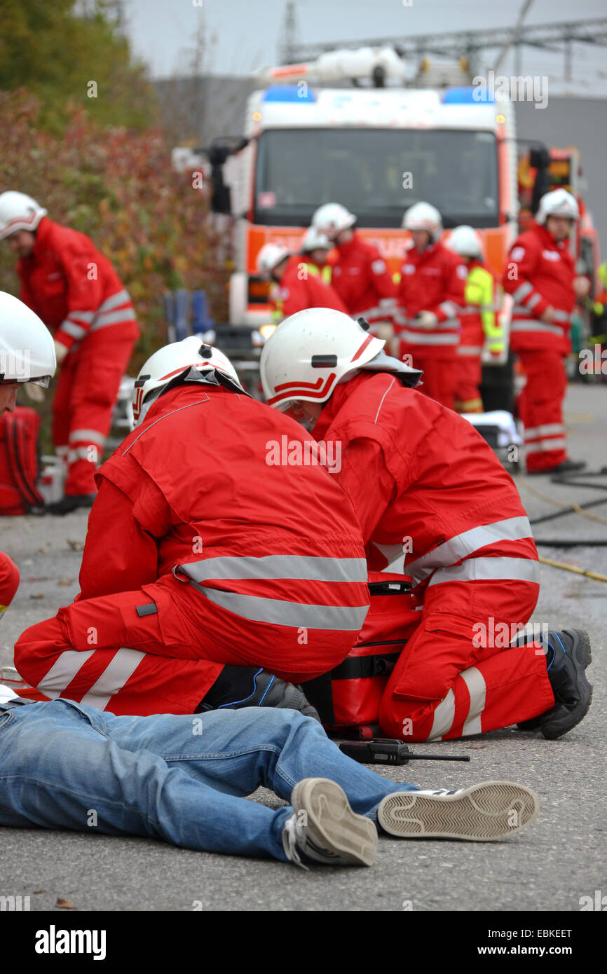 La formation des sapeurs-pompiers et les techniciens médicaux d'urgence à un accident avec personne grièvement blessée Banque D'Images