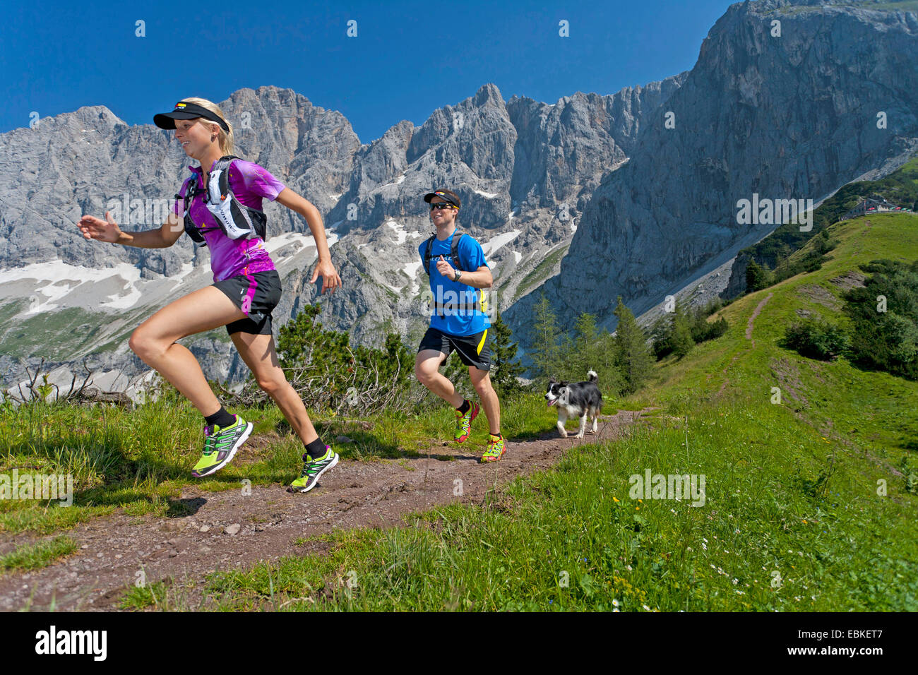 Border Collie (Canis lupus f. familiaris), young couple with dog trail running à la montagne Dachstein, Autriche, Styrie, Dachstein Banque D'Images