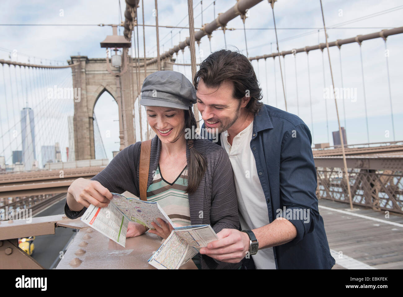 USA, l'État de New York, New York City, Brooklyn, heureux couple reading map on Brooklyn Bridge Banque D'Images