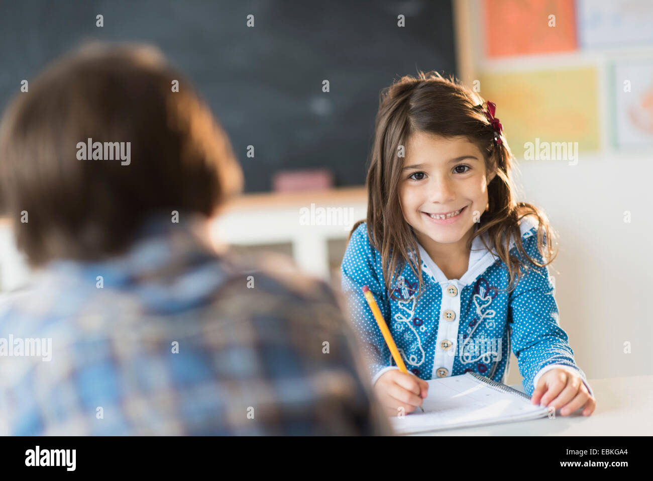 Élèves (6-7) l'apprentissage en classe, Girl (6-7) looking at camera Banque D'Images