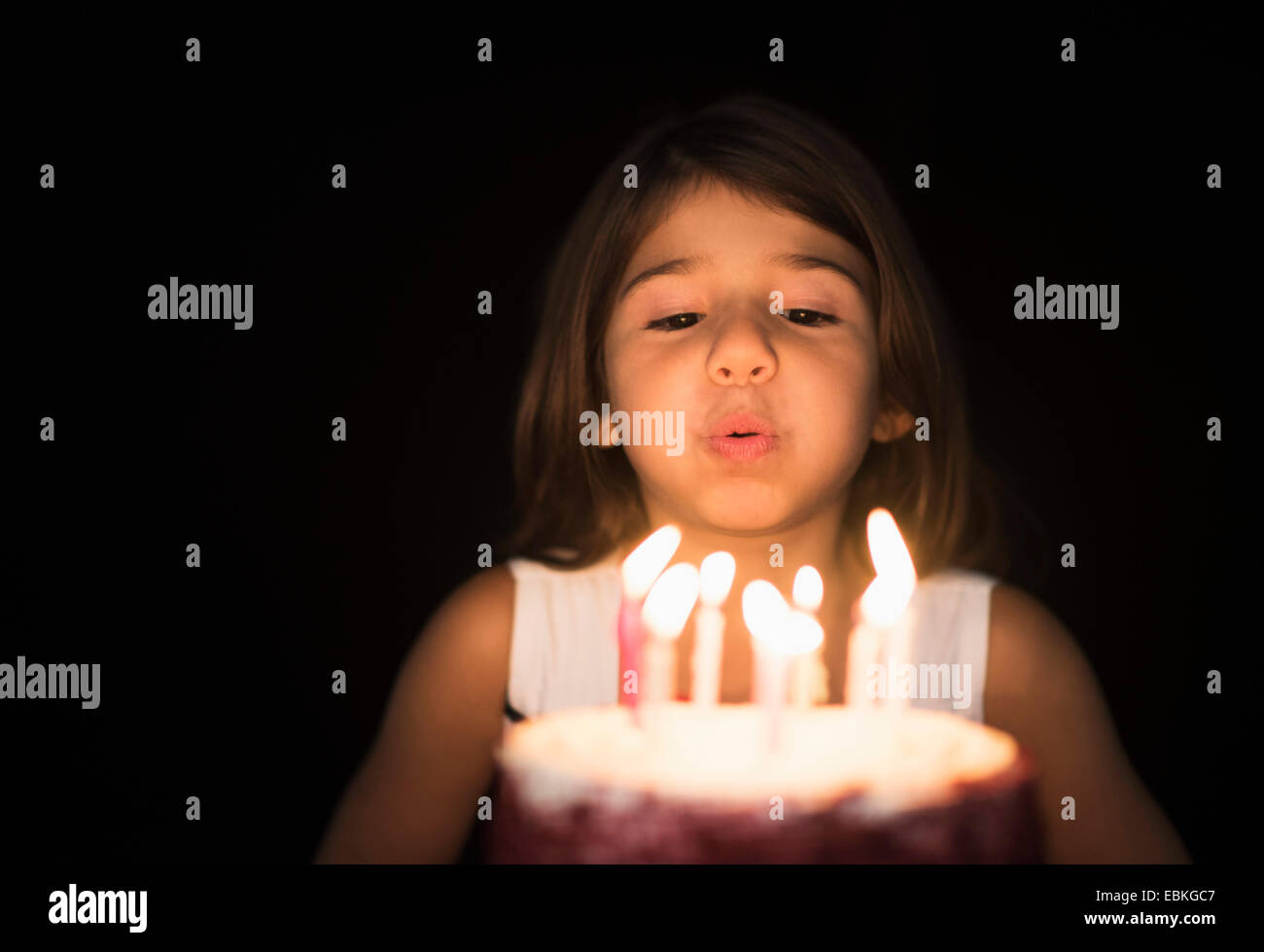 Portrait of Girl (6-7) blowing out birthday candles Banque D'Images