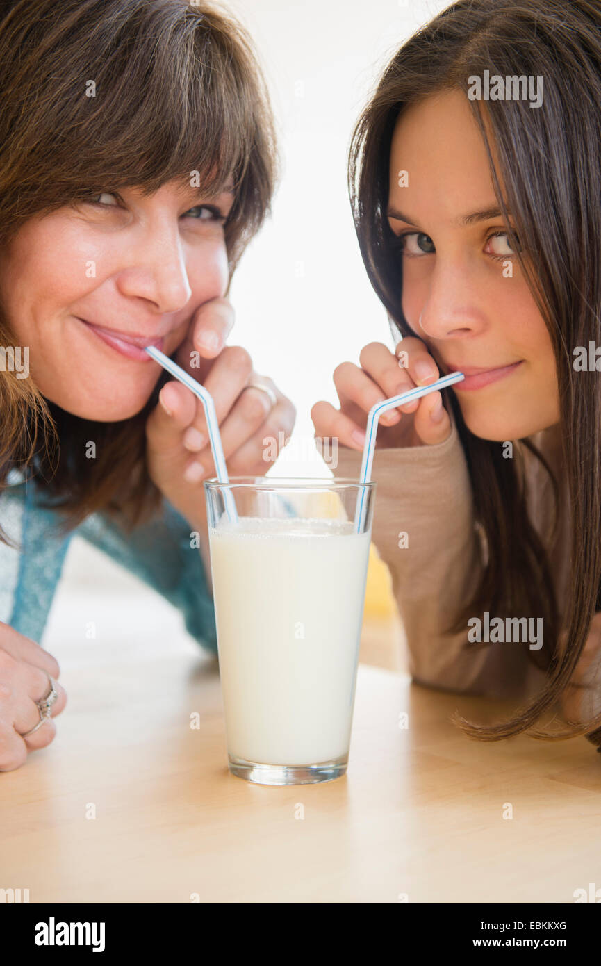 Teenage girl (14-15) boire du lait avec sa maman à la maison Banque D'Images