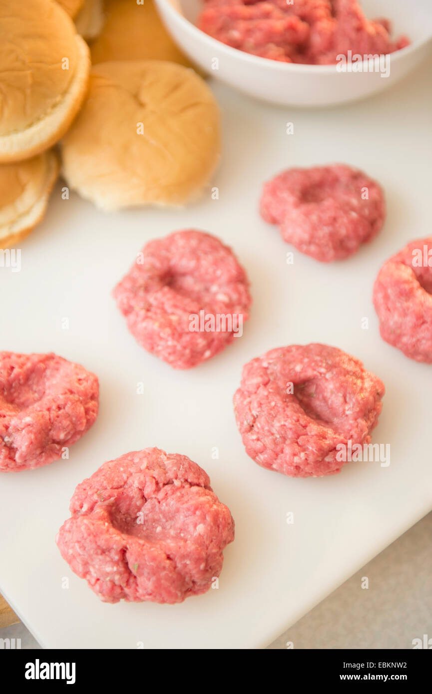 Gros plan sur les boulettes de viande dans la rangée sur la planche à découper blanc Banque D'Images