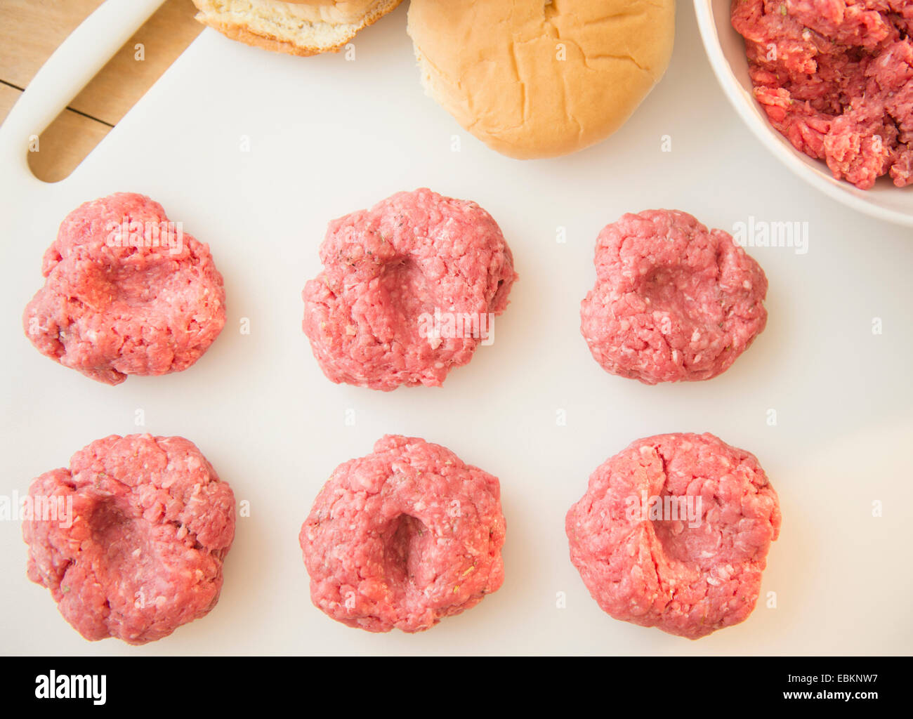 Gros plan sur les boulettes de viande dans la rangée sur la planche à découper blanc Banque D'Images