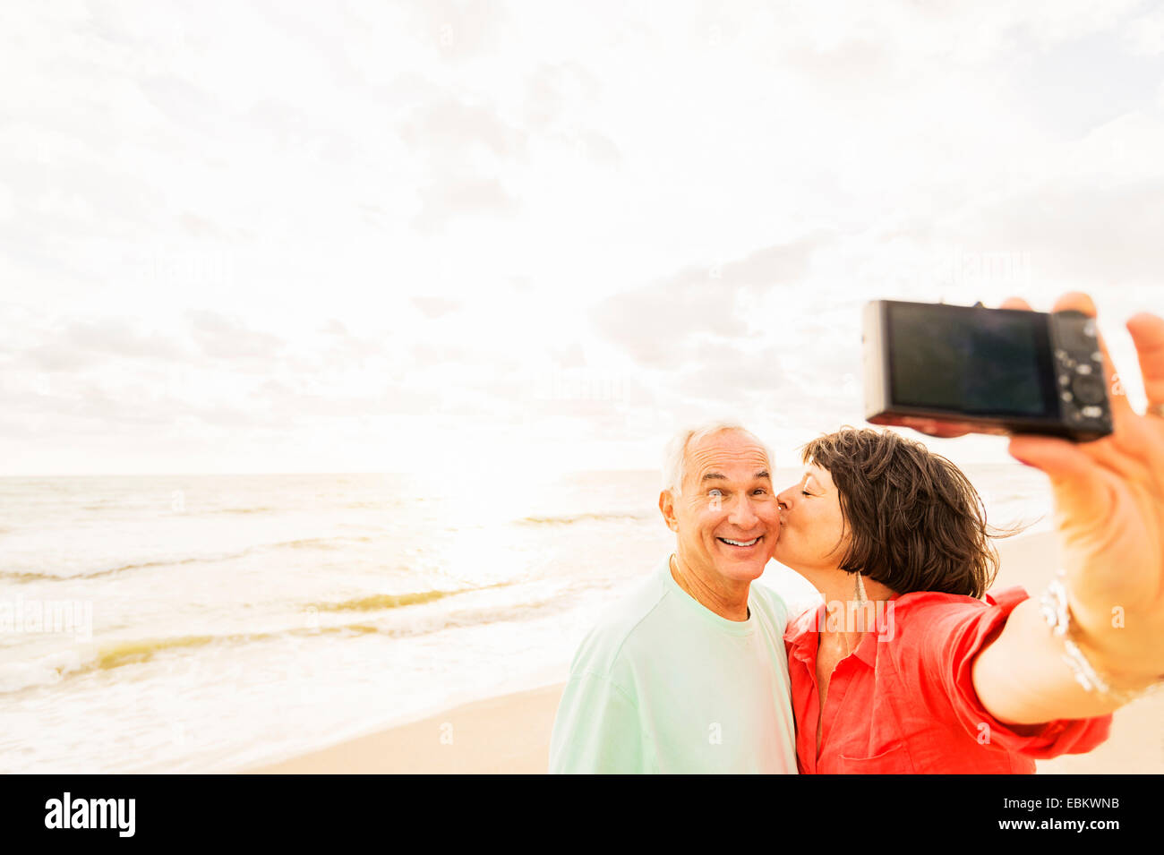 USA, Floride, Jupiter, couple sur la plage au lever du soleil selfies Banque D'Images