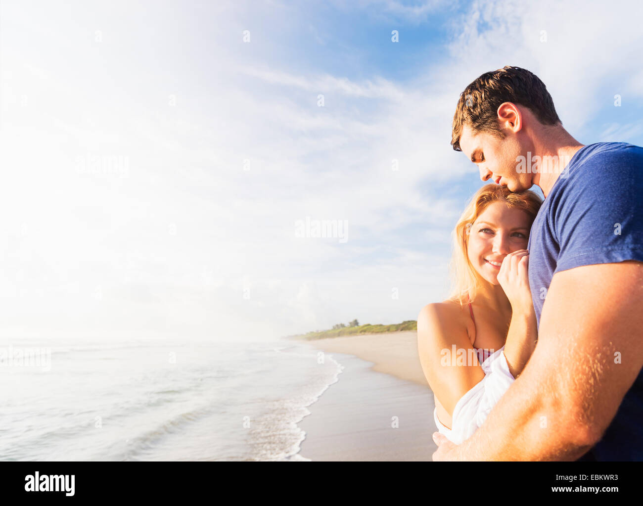 USA, Floride, Jupiter, Portrait of young couple embracing on beach, contre l'arrière-plan de littoral Banque D'Images