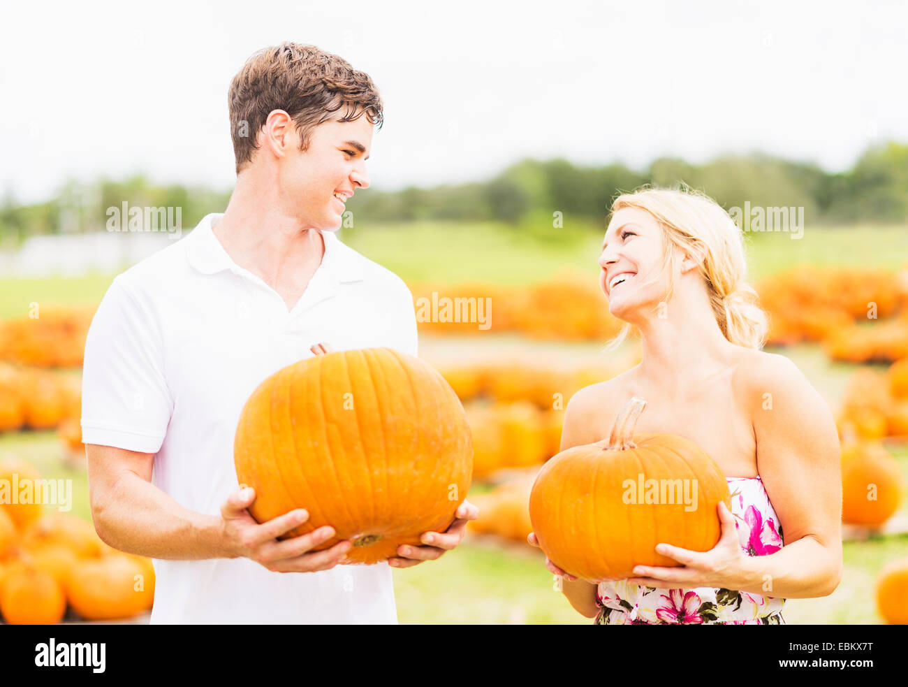 USA, Floride, Jupiter, Portrait of young couple holding pumpkins Banque D'Images
