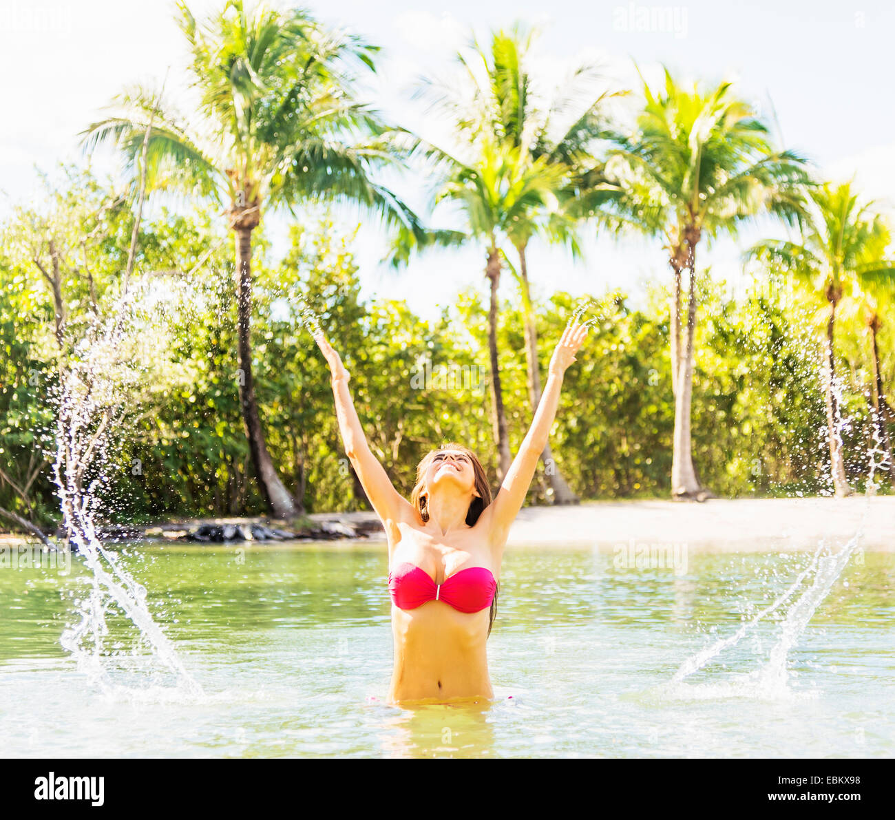 USA, Floride, Jupiter, Portrait of young woman wearing bikini aux projections d'eau dans le lagon tropical Banque D'Images