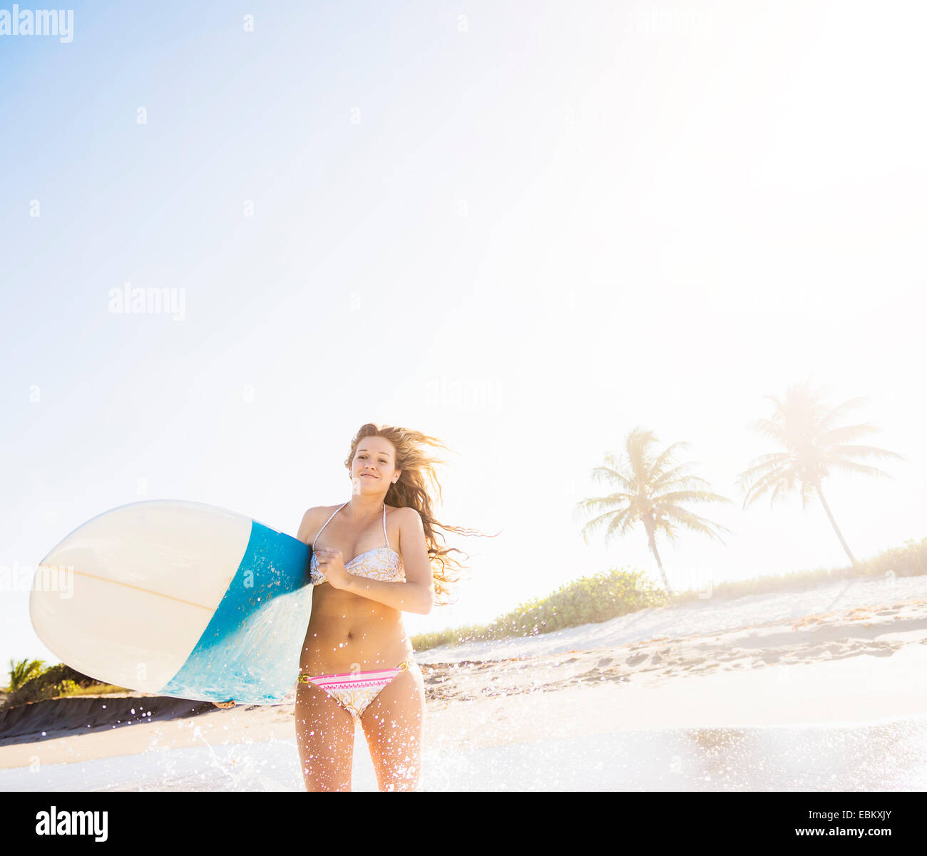 USA, Floride, Jupiter, young woman running in surf surfboard comptable Banque D'Images
