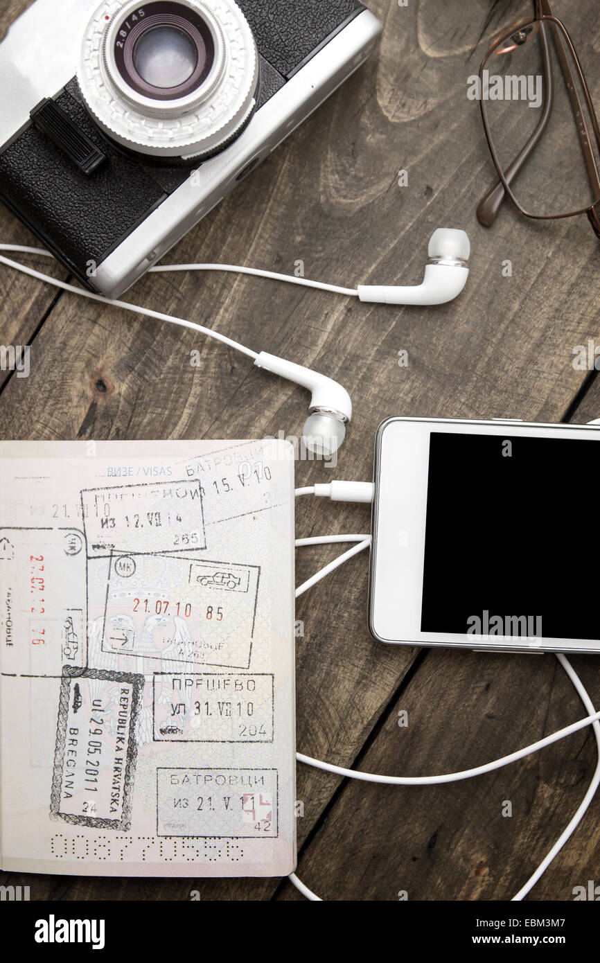 Préparation pour le voyage, d'un téléphone cellulaire, appareil photo, passeport on wooden table Banque D'Images