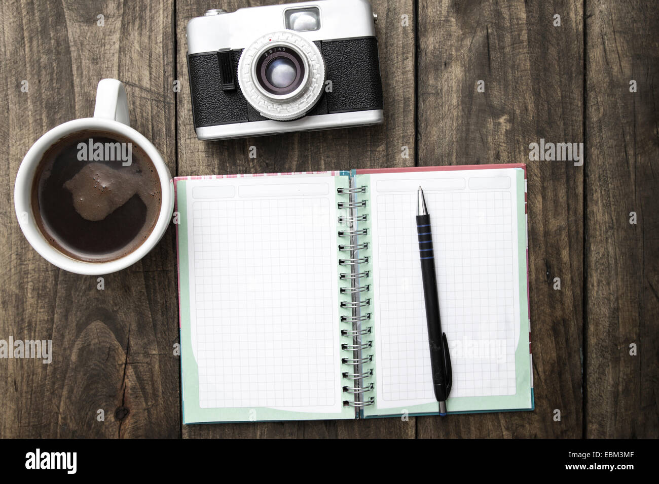 Vintage camera, journal intime avec poêle et tasse de café pf sur table en bois. Banque D'Images