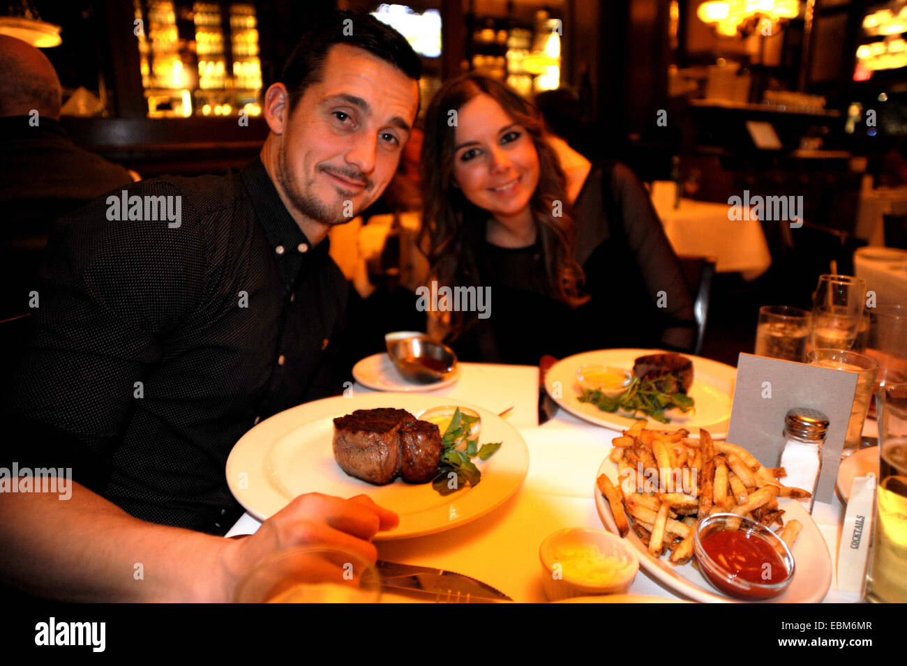 Jeune couple profitez d'une soirée à Bobby Van's Steakhouse West 50th Street New York avec de la lave de filet mignon de boeuf Banque D'Images