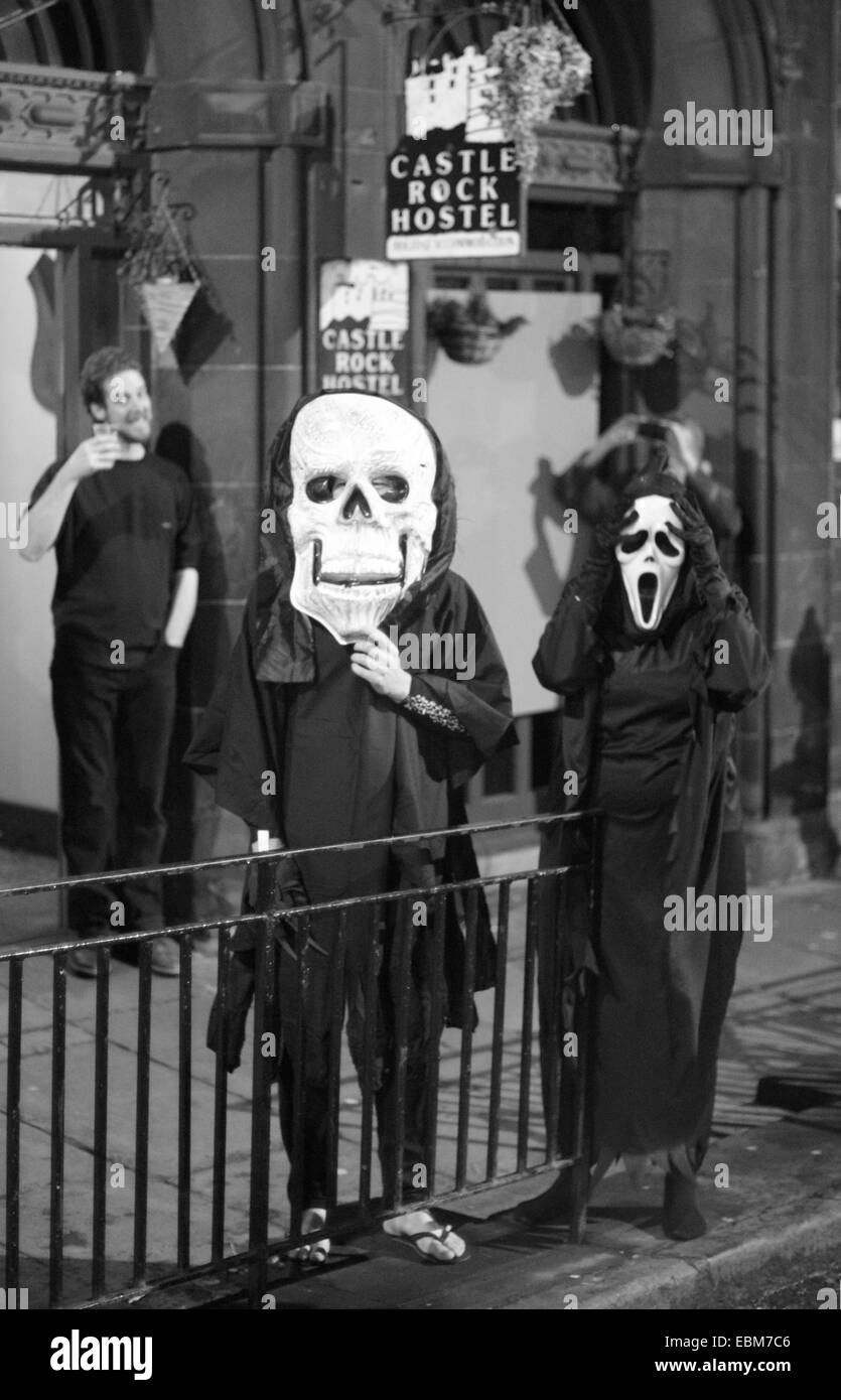 Deux spectateurs en costume portant torches brûlant des interprètes à l'Samhuinn sur Halloween Festival à Édimbourg, Écosse, Royaume-Uni Banque D'Images