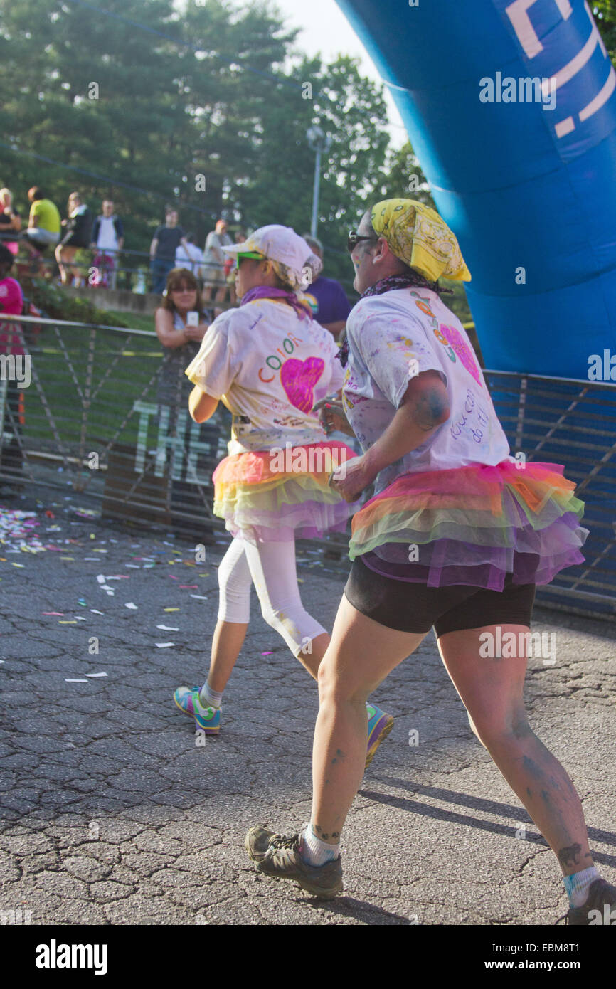 Les coureuses portant tutus éclaboussés de colorant coloré dans la course l'heureux Asheville 5K Color Run Banque D'Images