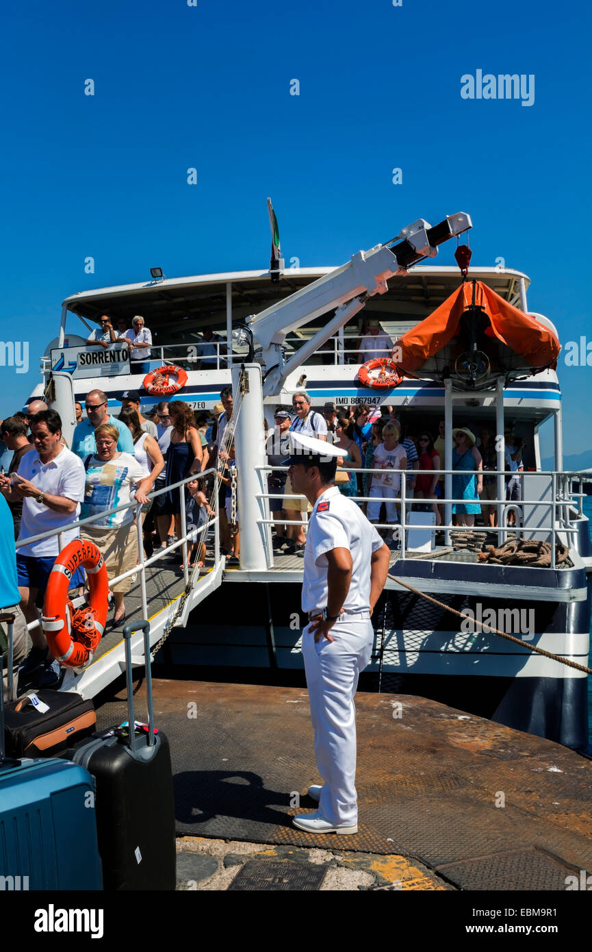 Ce matelot supervise les personnes débarquant d'un bateau. Le ferry a tout juste d'arriver à l'île de Capri, Italie. Banque D'Images