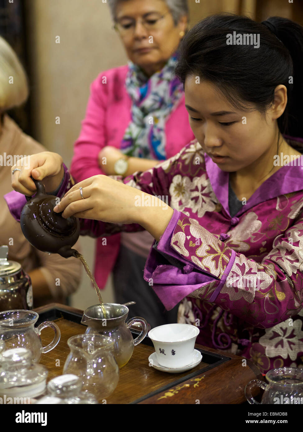 Young woman pouring tea au cours d'une cérémonie de thé chinois traditionnel Banque D'Images