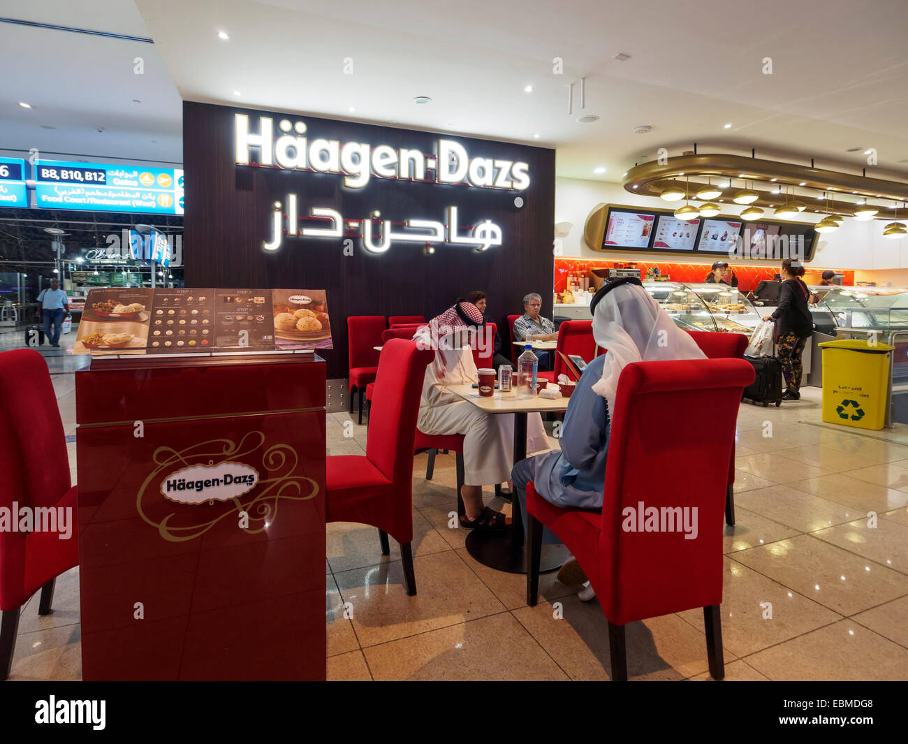 Les Arabes assis à une table à l'Haagen-Dazs visitez l''aéroport International de Dubai Banque D'Images