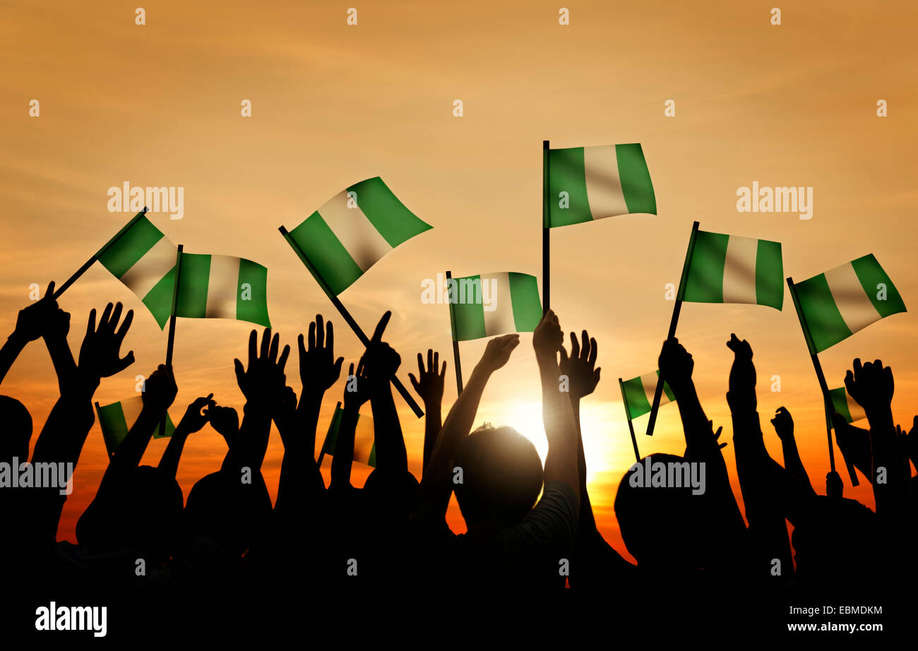 Groupe de personnes Waving Flag du Nigéria à l'arrière allumé Banque D'Images