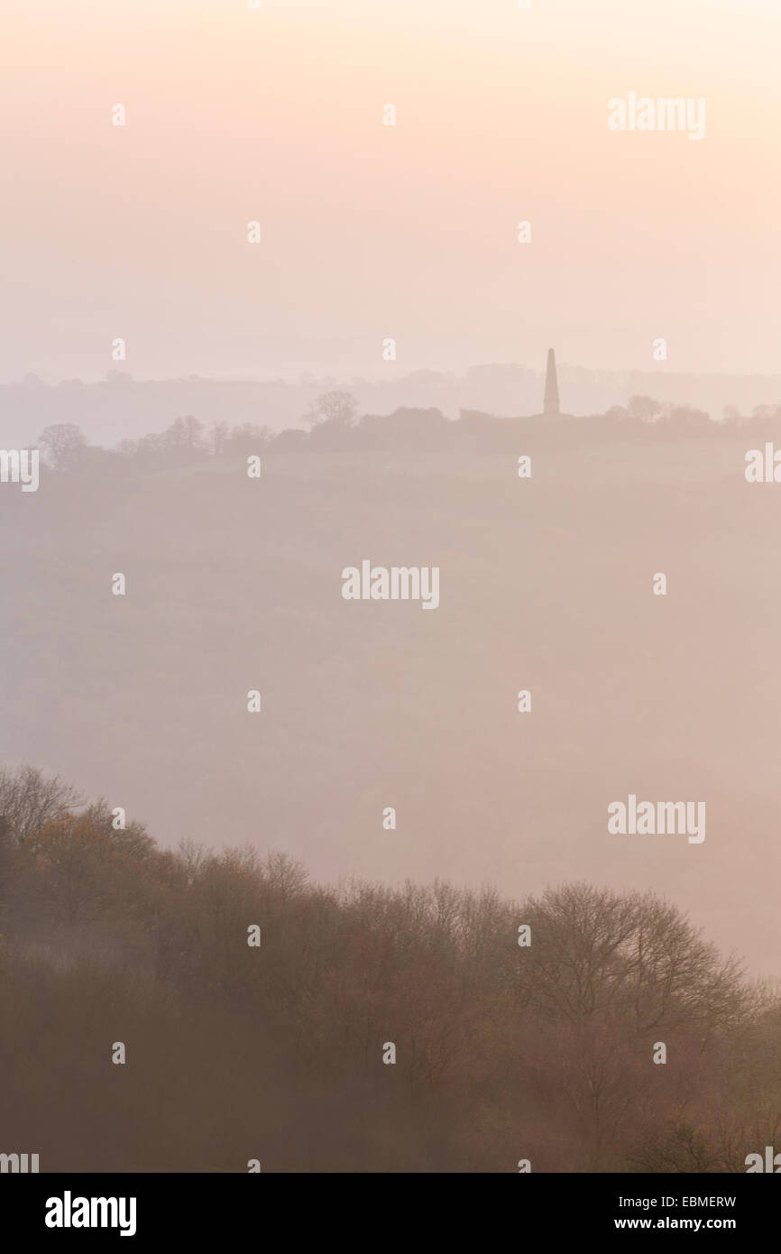 La silhouette de l'Obélisque à Eastnor peut être vu à travers le brouillard de la Camp sur les collines de Malvern. Banque D'Images