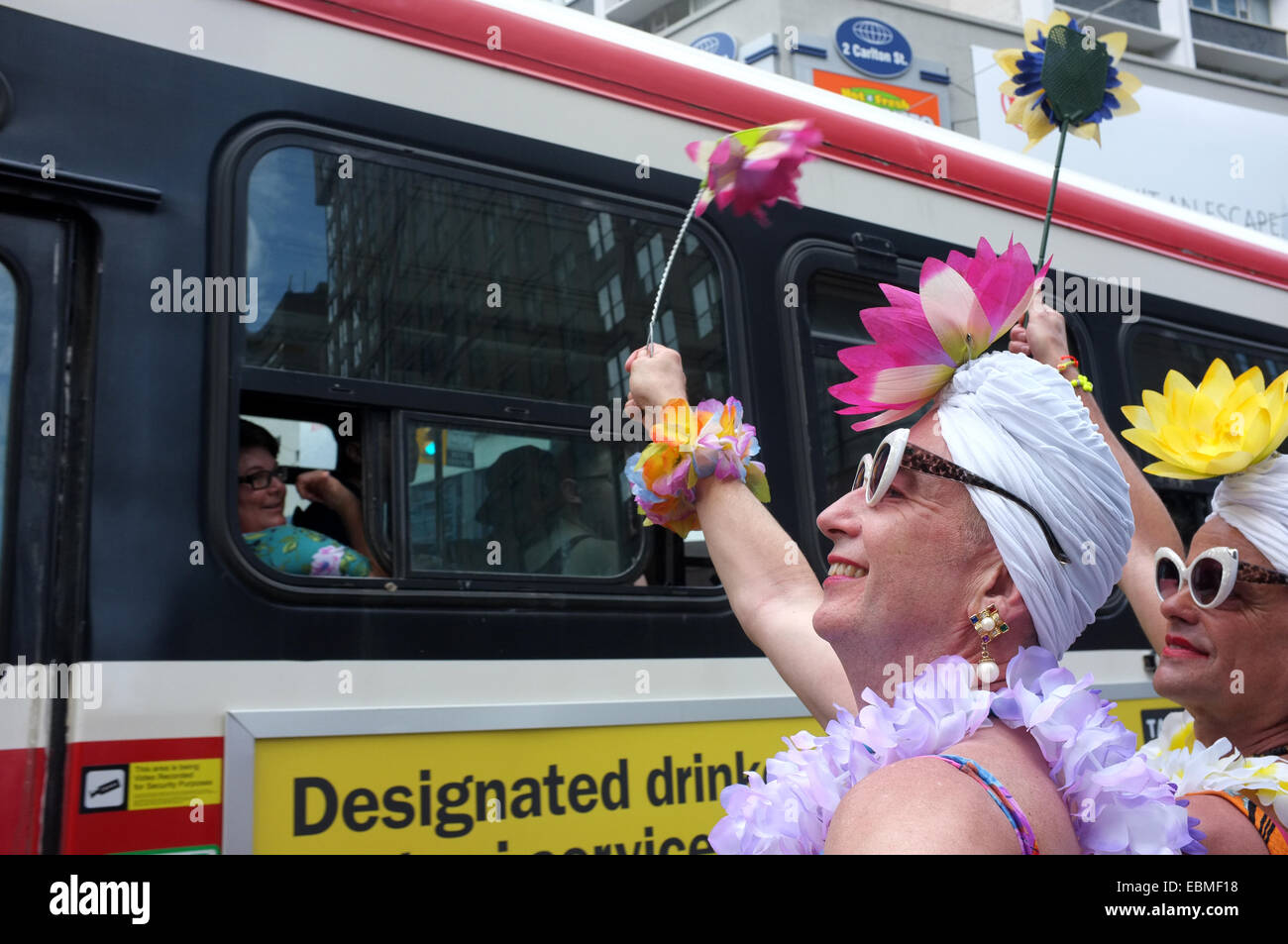 Des hommes à la vague glisser à un tramway qui passe à la World Pride 2014 à Toronto. Banque D'Images