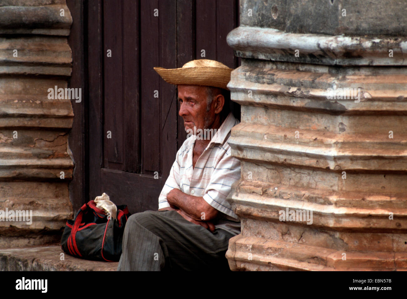 Homme avec chapeau de paille assis à une entrée privée, Paraguay, Piribebuy Banque D'Images