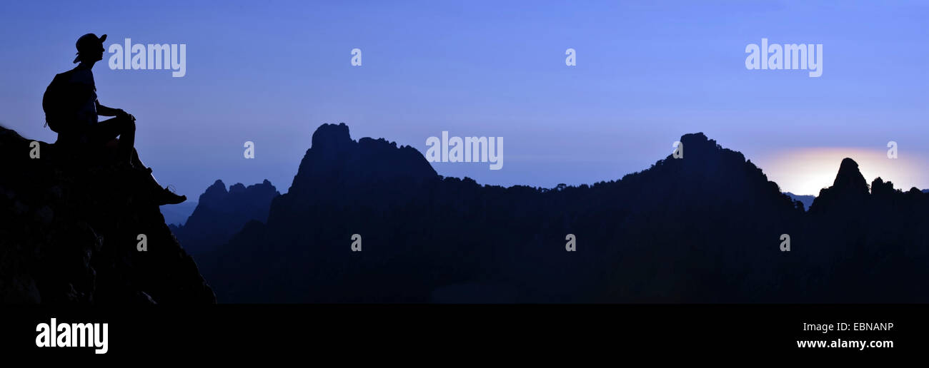 Wanderer assis sur un rocher et profiter de la vue sur les montagnes de Bavella le matin, France, Corse, Porto Vecchio Banque D'Images